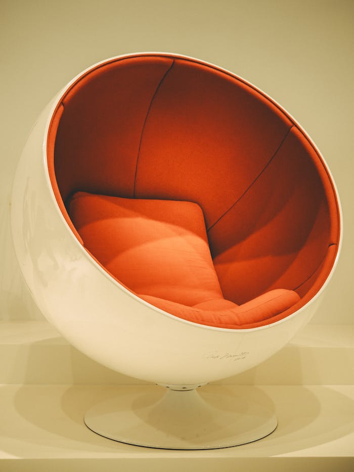 Stylish red and white egg chair in a contemporary setting with clean lines and vintage flair.